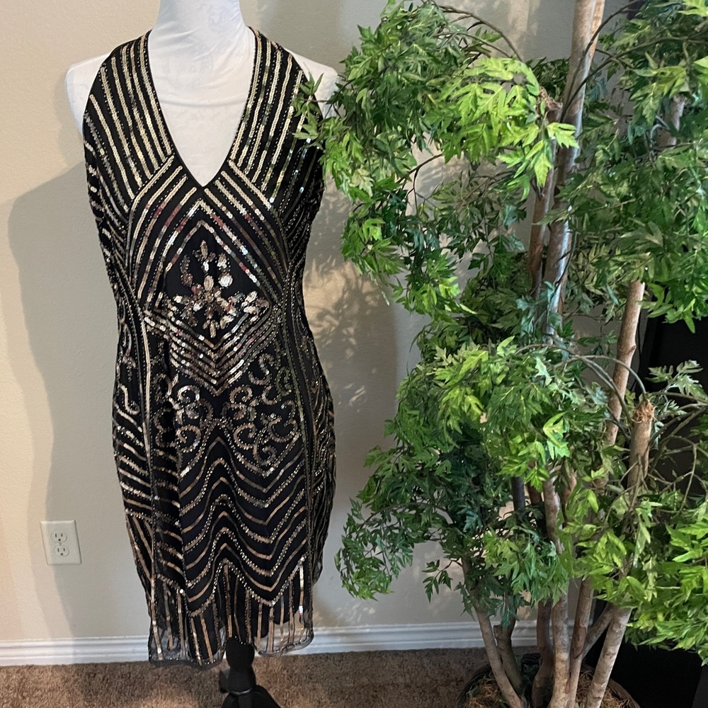 Black halter dress with gold sequin accents.